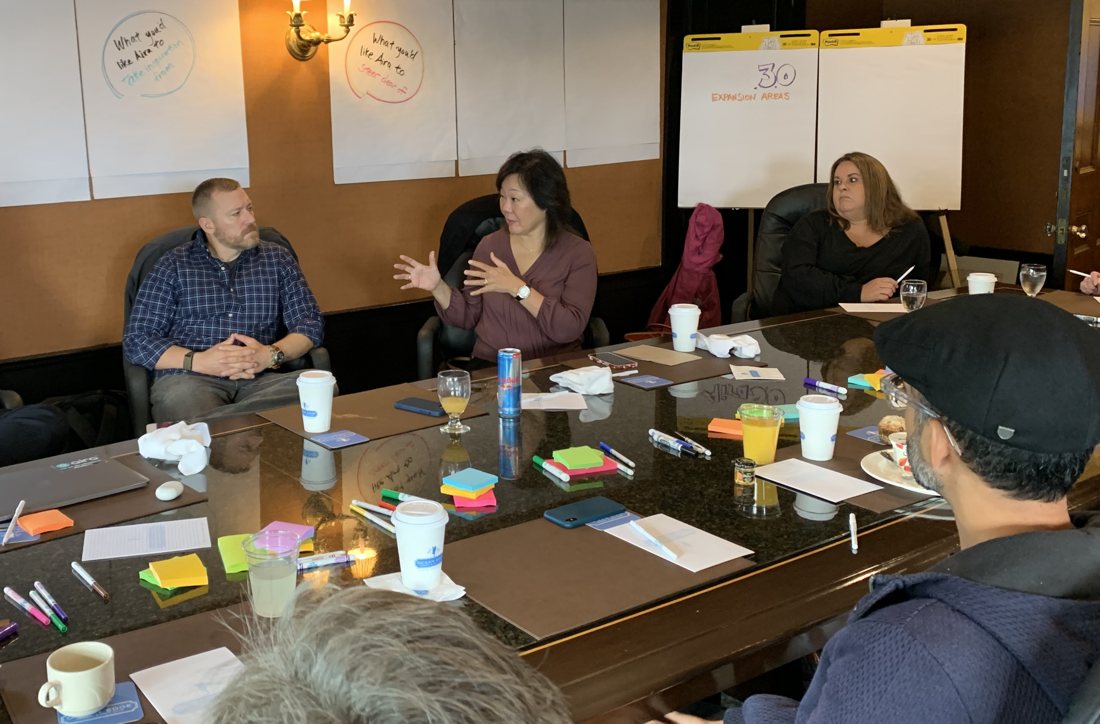Frances West facilitating a strategy workshop with leaders around a conference table